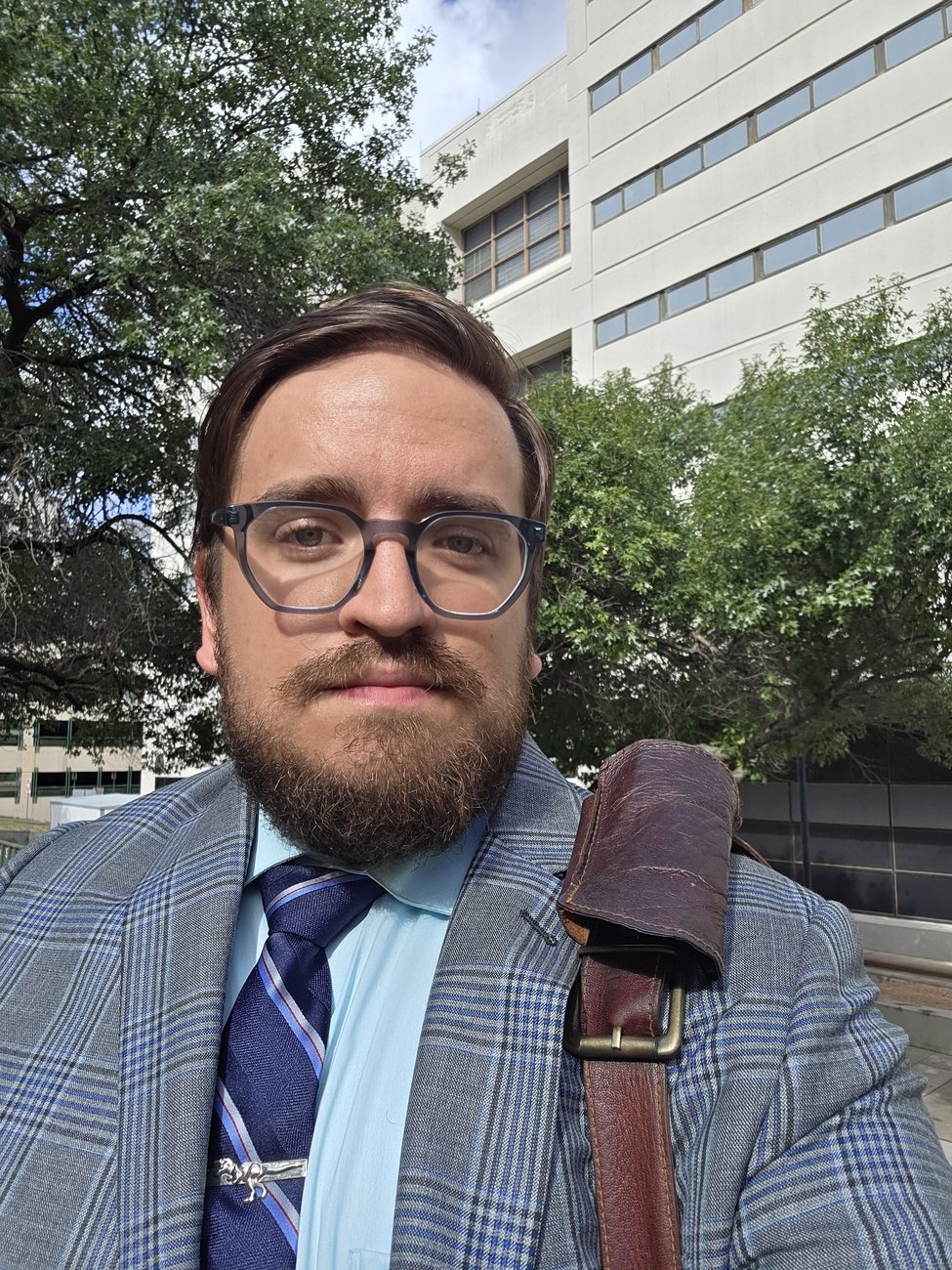 Taylor Matthews suited up outside a Texas courthouse